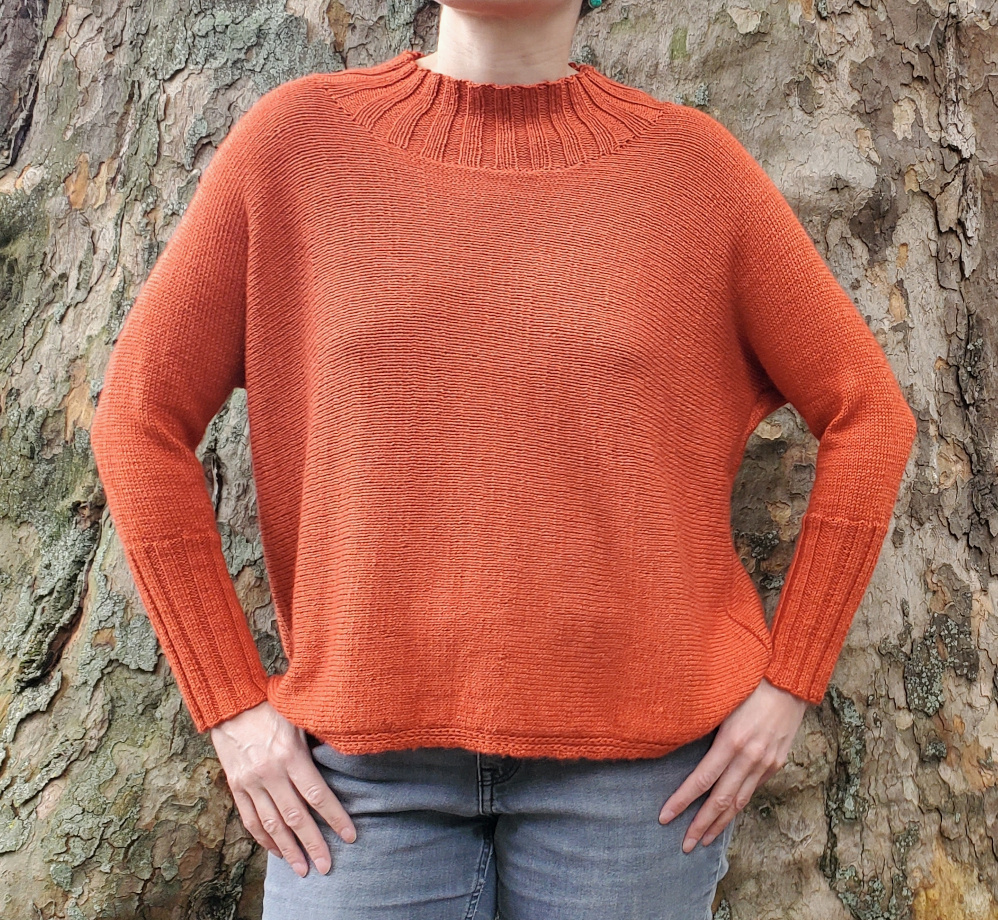 Modell trägt rostorangenen Strickpullover